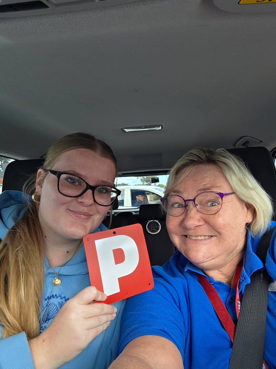 Lisa Archer in the car with a smiling student holding her P plate
